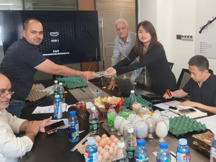Finalizing the contract details for the egg tray production line with the client.